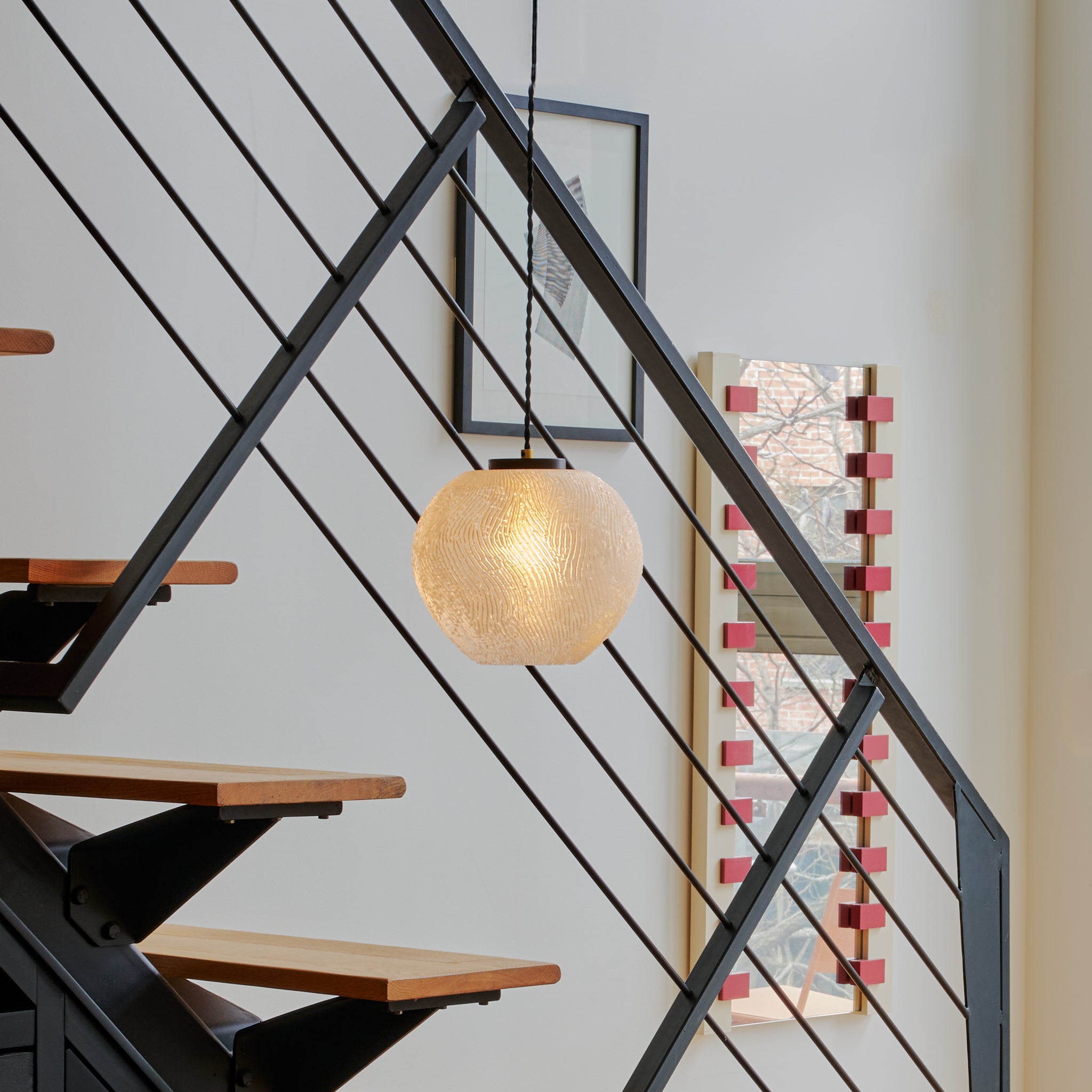 Image of Coral Pendant in front of steel staircase
