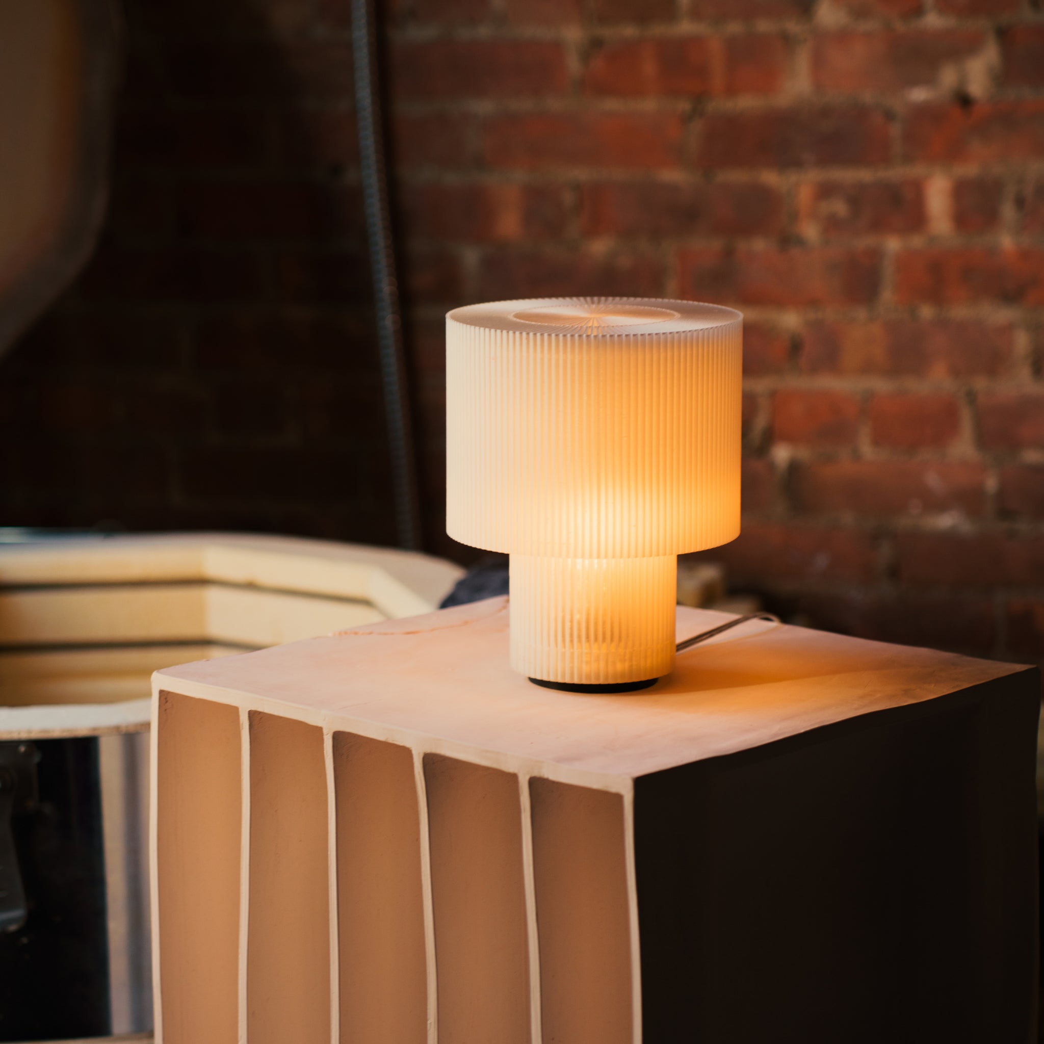 Image of Drum Lamp in front of brick wall