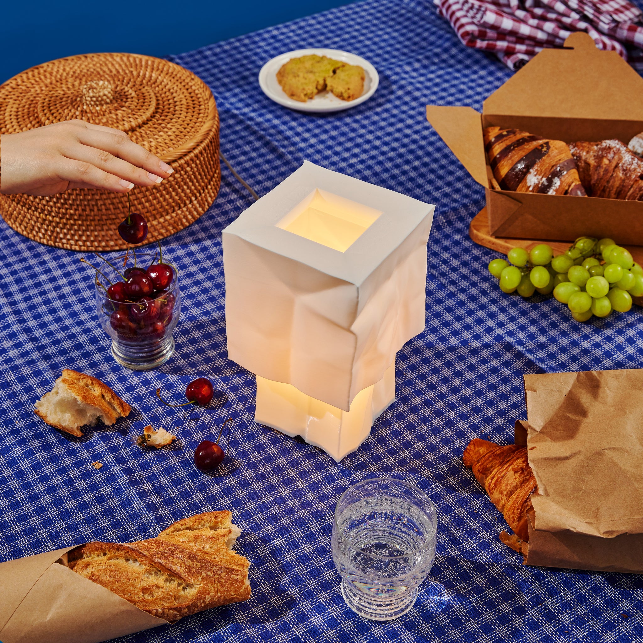 Farolito Lamp on picnic blanket with pastries and fruit
