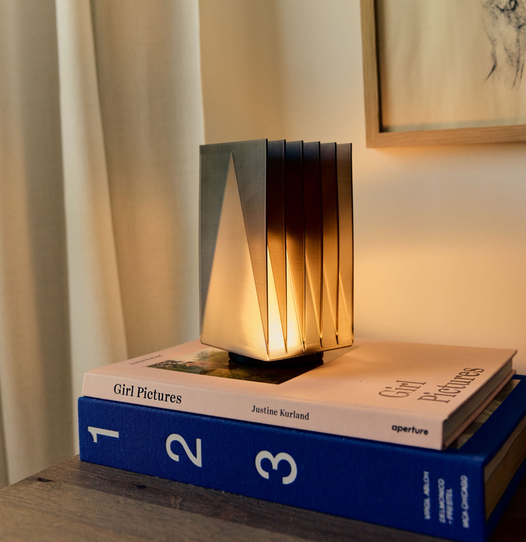 Cordless Fin Lamp in Smoke on stack of books