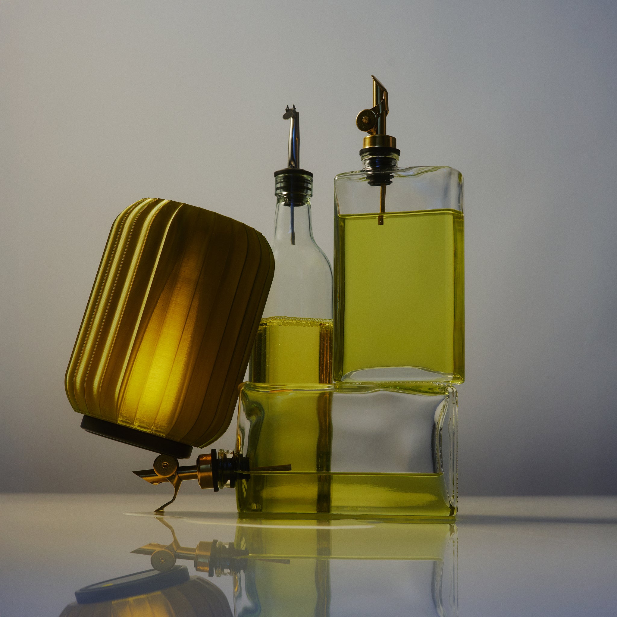Cordless Mini Allium Lamp in Olive Oil next to bottles of olive oil