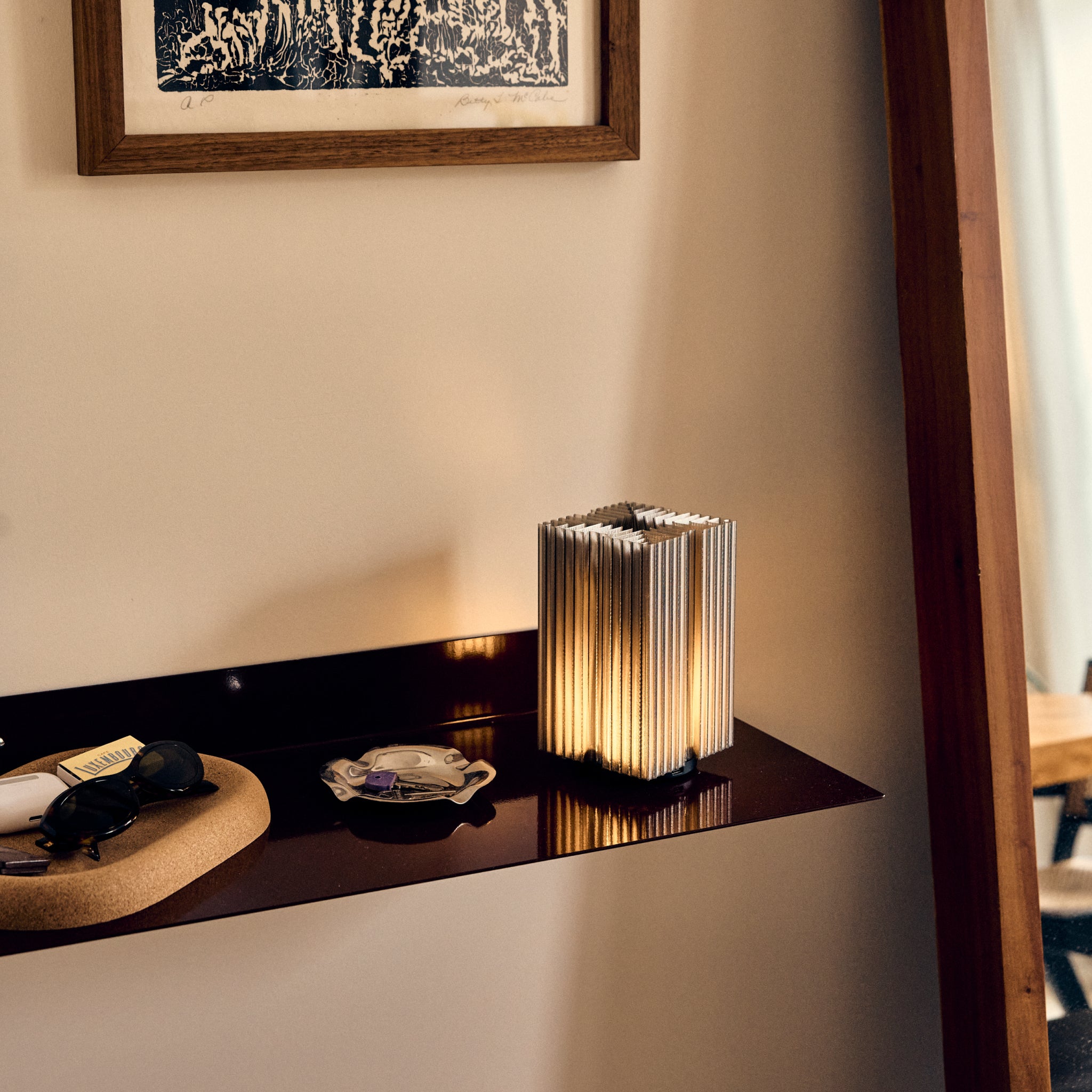 Cordless mini brut lamp in smoke on entryway shelf
