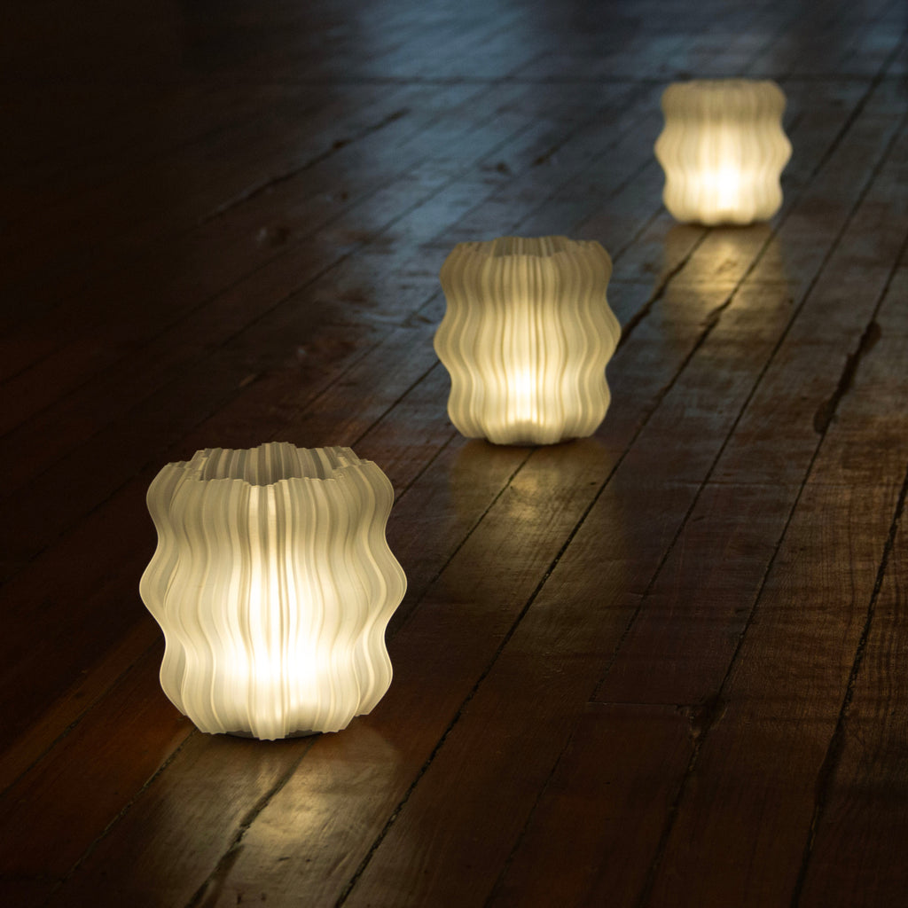 Cordless Mini Wavy Lamps lined up on wooden floor