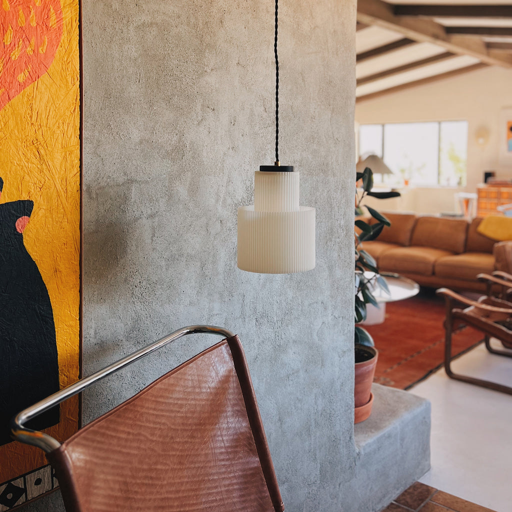 Image of Drum Pendant in front of a cement wall inside a contemporary living room