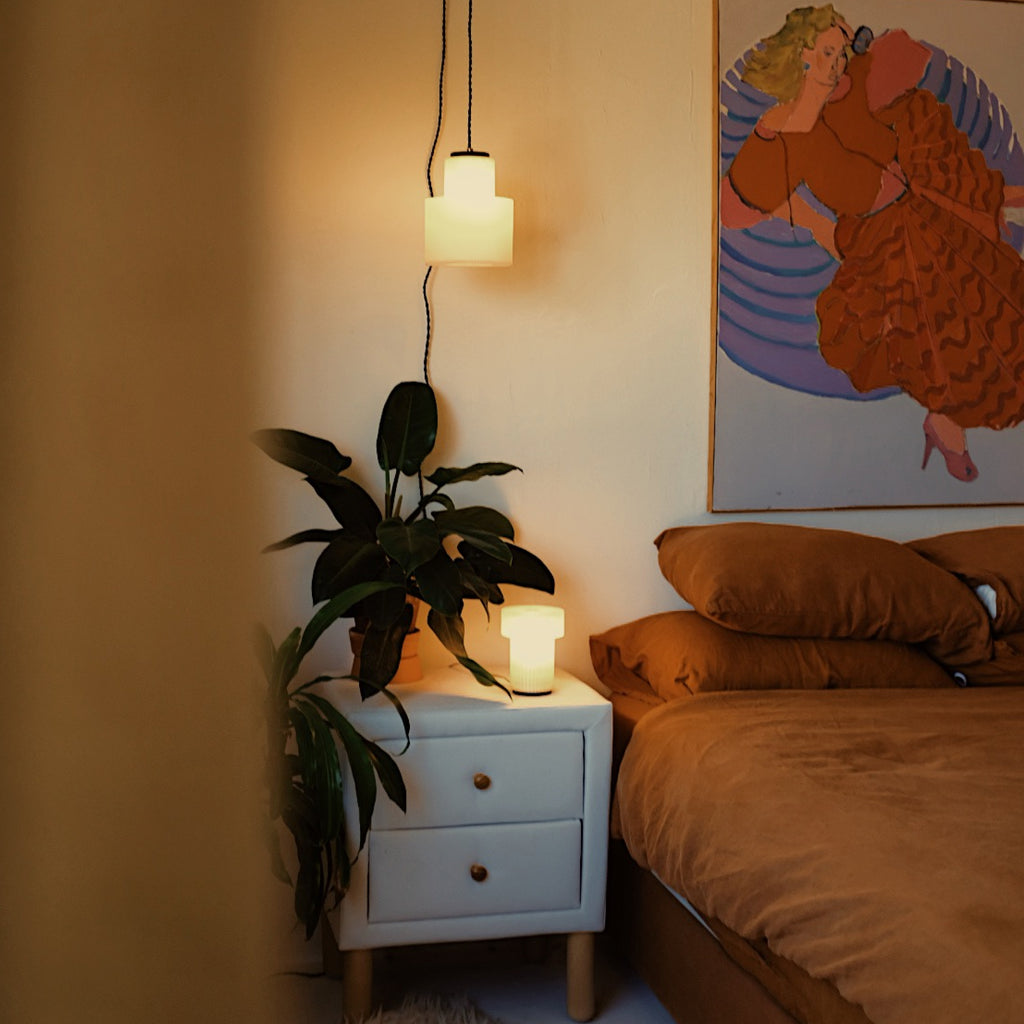 Image of Drum Pendant in a cozy bedroom displaying a warm glow