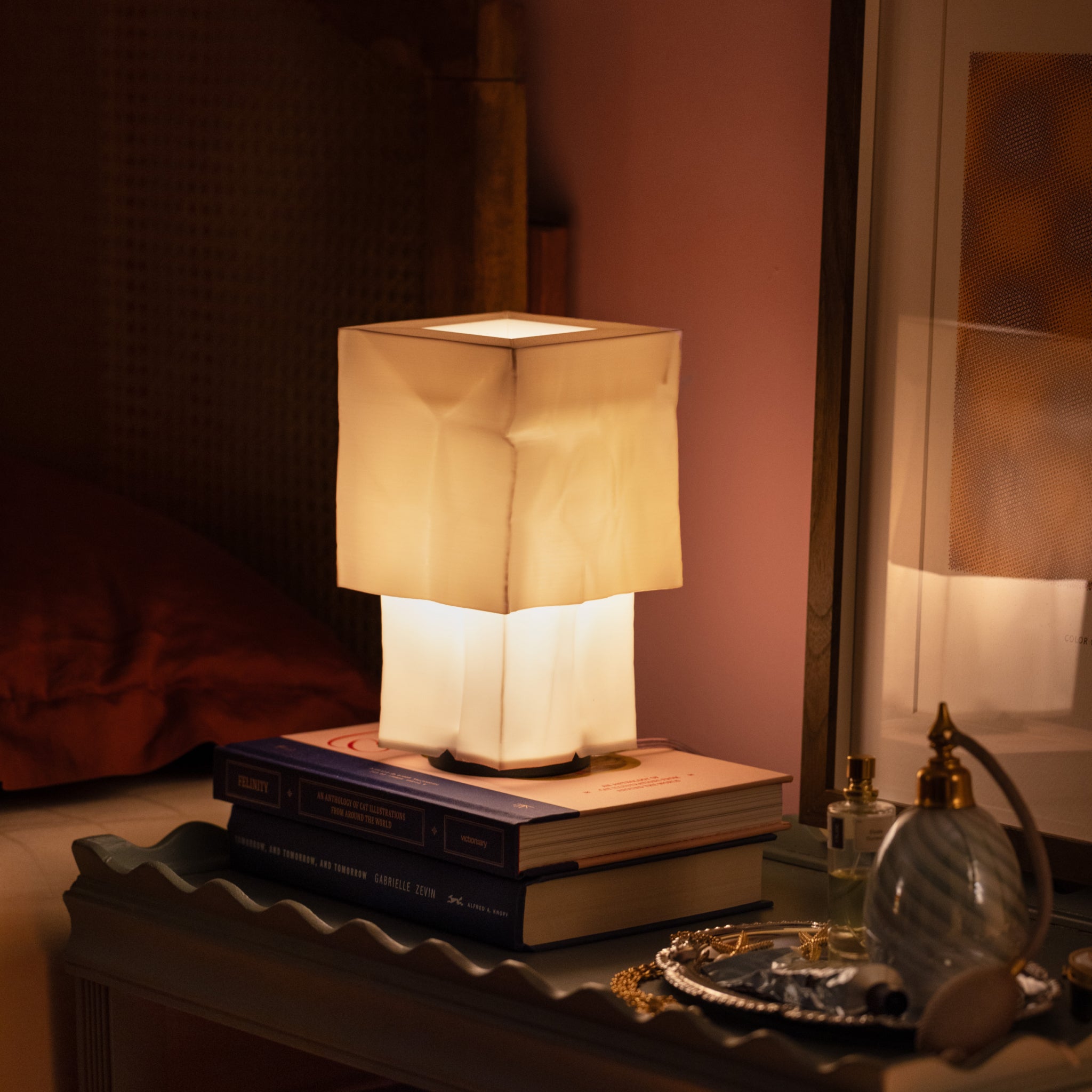 Farolito Lamp on stack of books next to framed picture