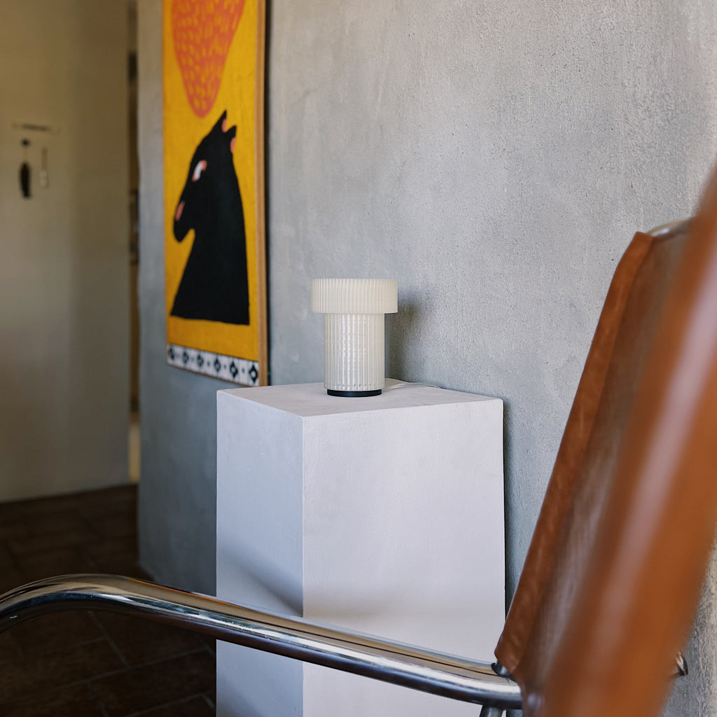 Image of Mini Drum Lamp in front of a cement wall in a modern living room