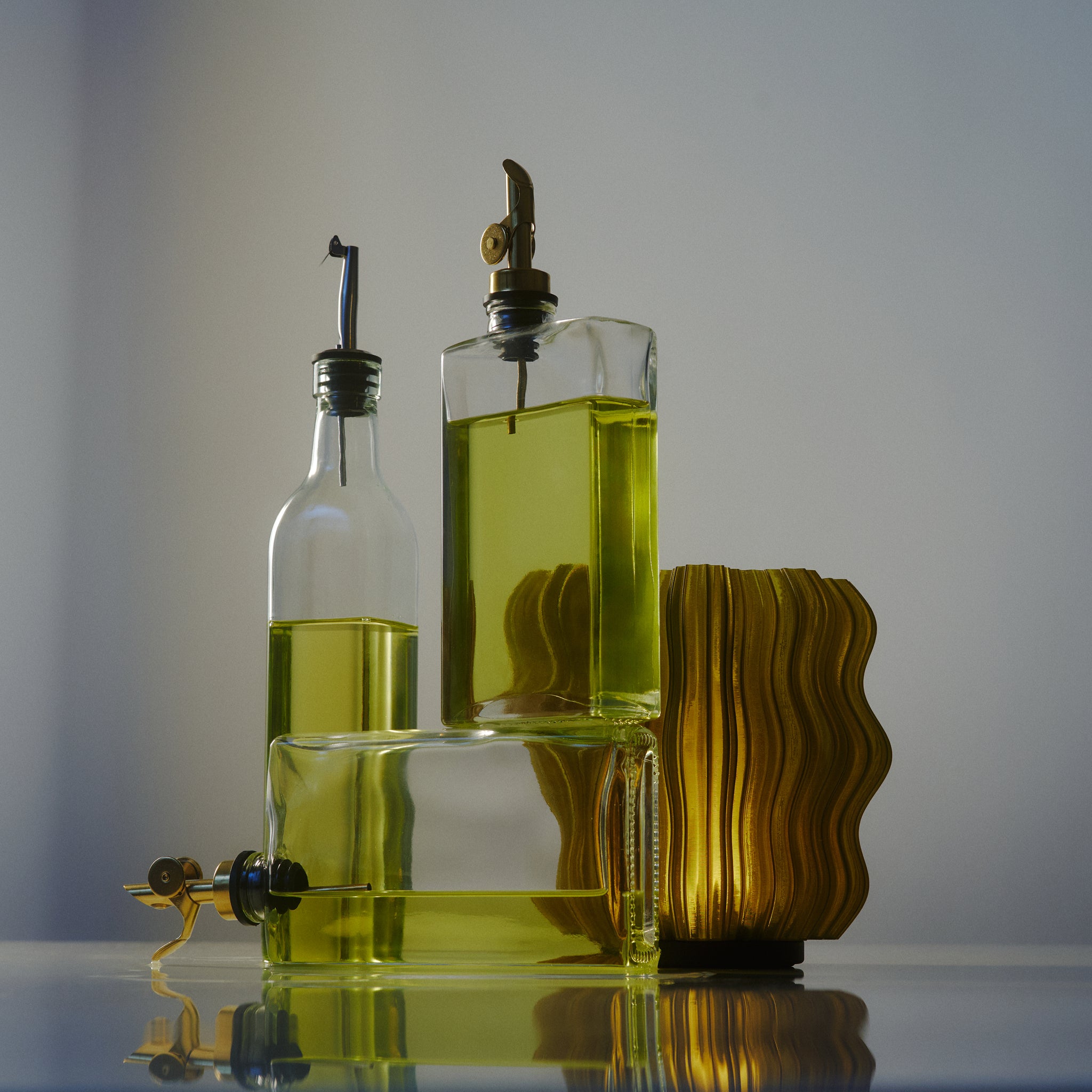 Mini Wavy Lamp in Olive oil next to bottles of olive oil
