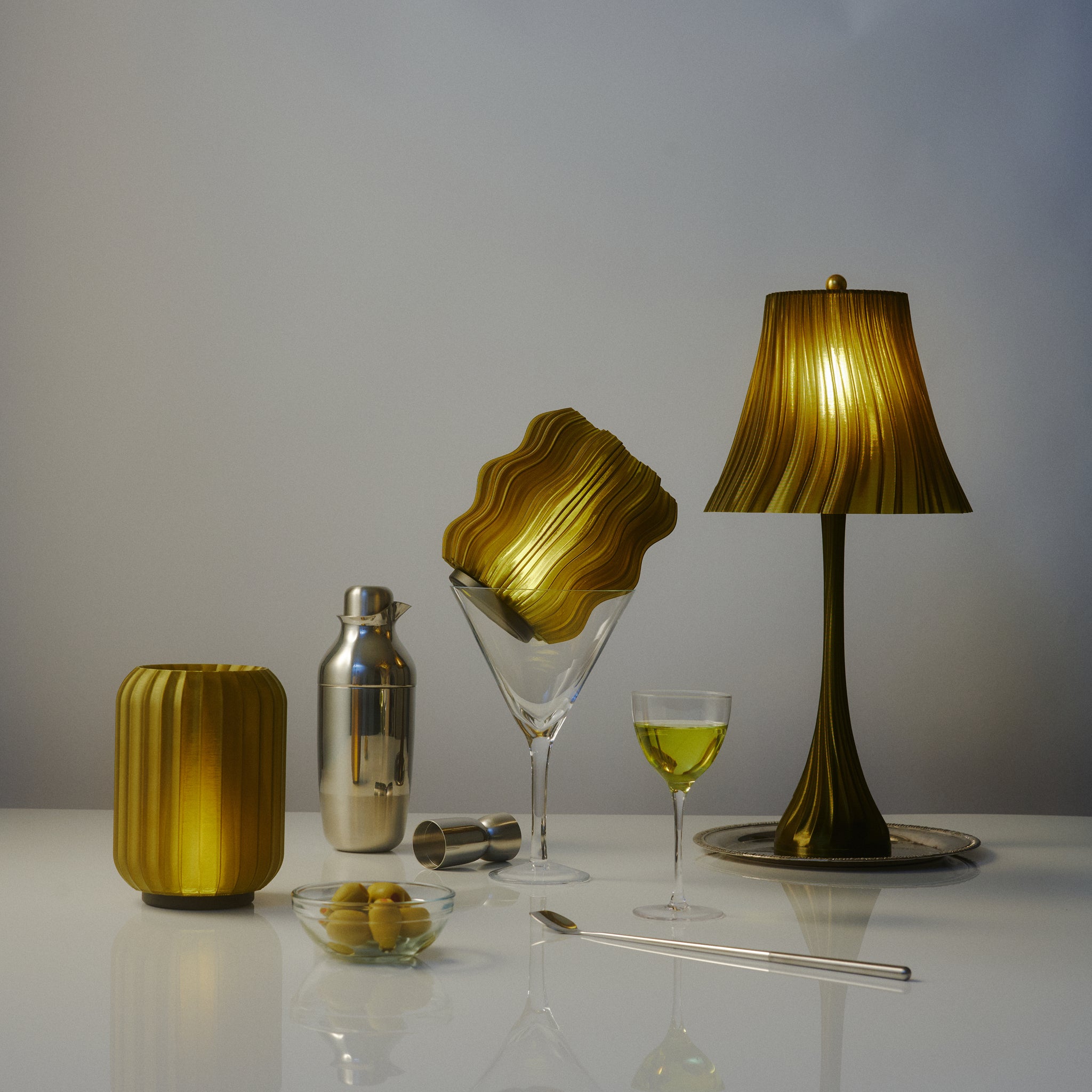 Pleat Lamp, mini wavy lamp, and mini allium lamp in olive oil with martini glasses