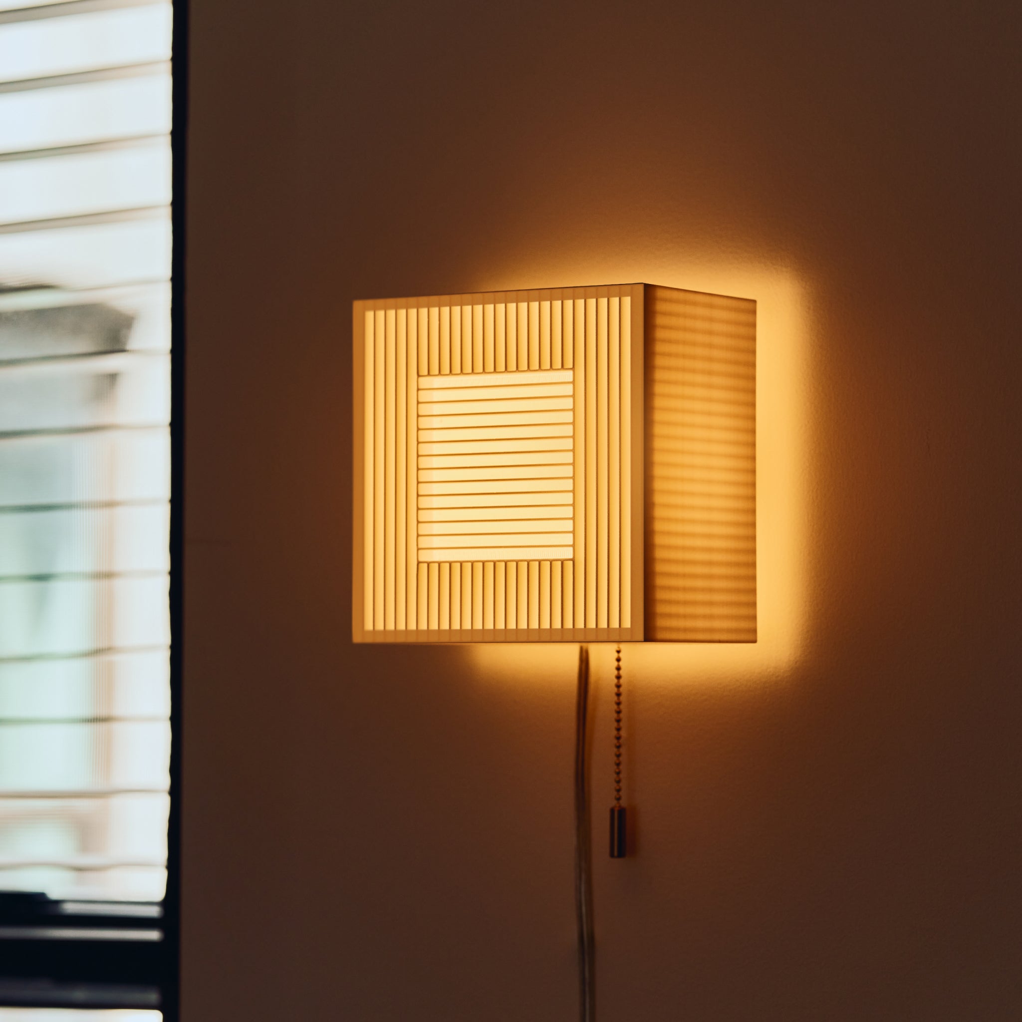 Palindrome Sconce in white next to window