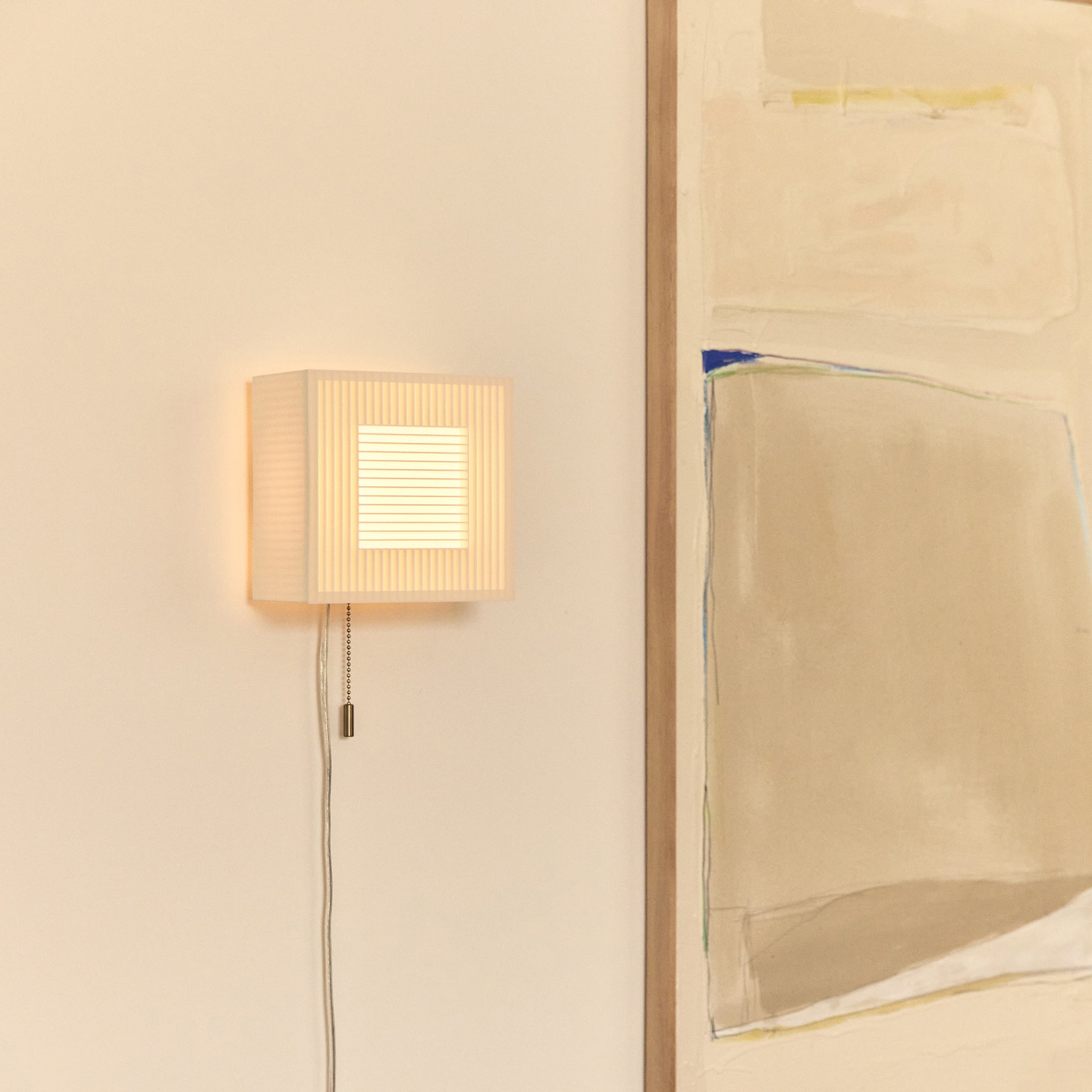 Palindrome Sconce in white next to painting