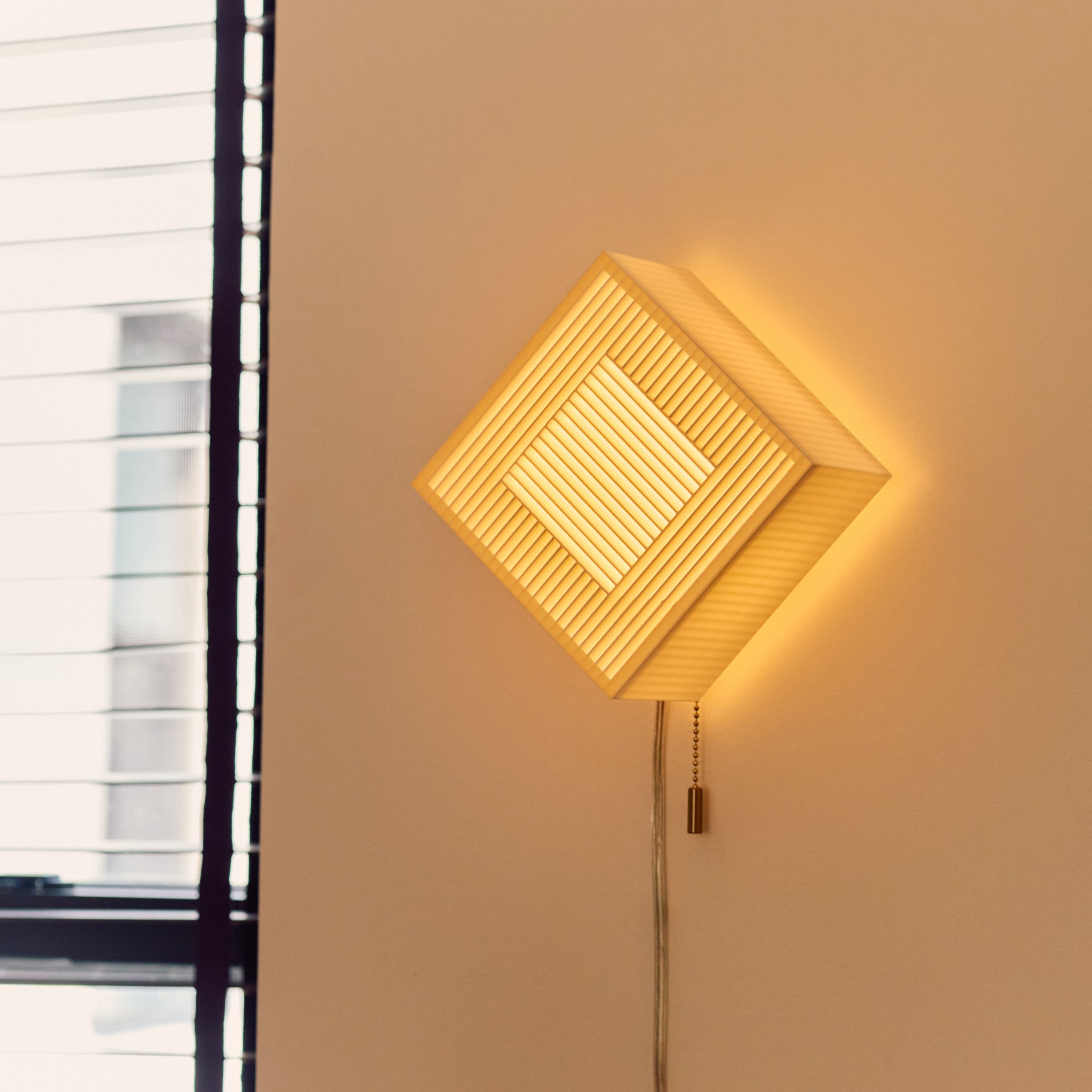 Palindrome Sconce in white, rotated, next to window