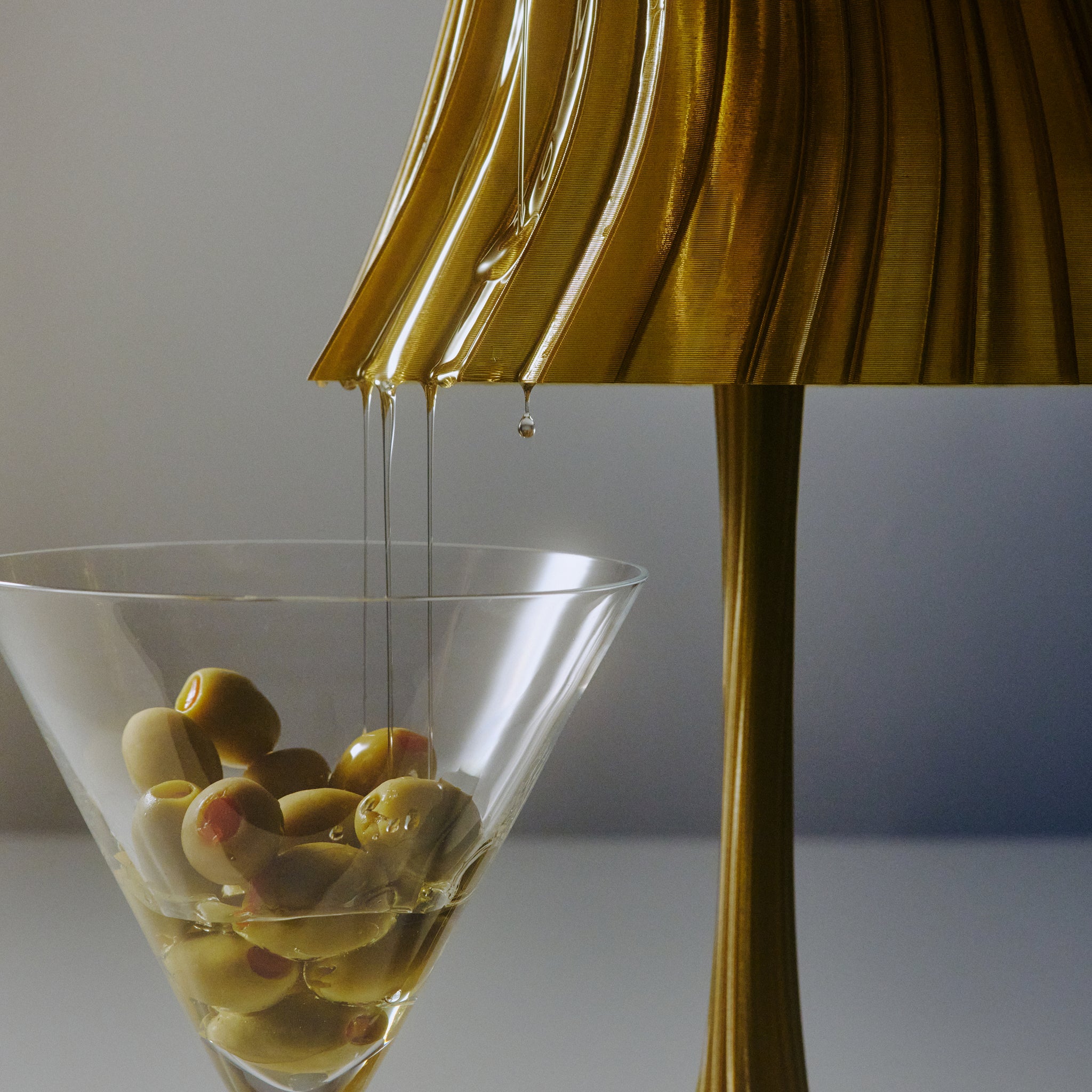Closeup of Pleat Lamp shade in olive oil with glass of olives