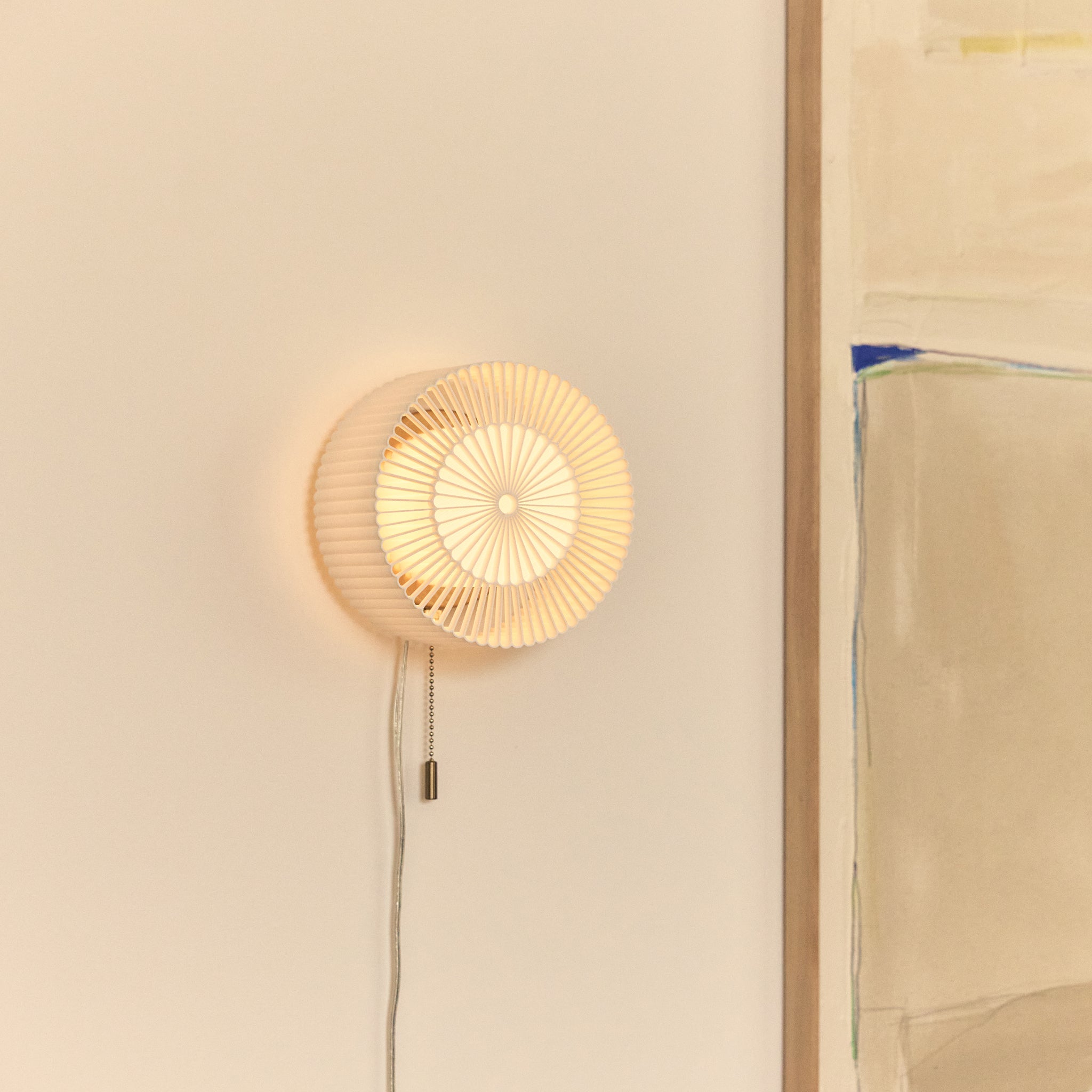 Rosette Sconce in White next to painting 