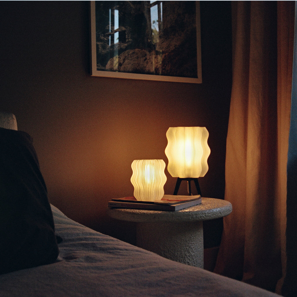 Wavy Lamp in matte black and Mini Wavy Lamp in natural on bedside table