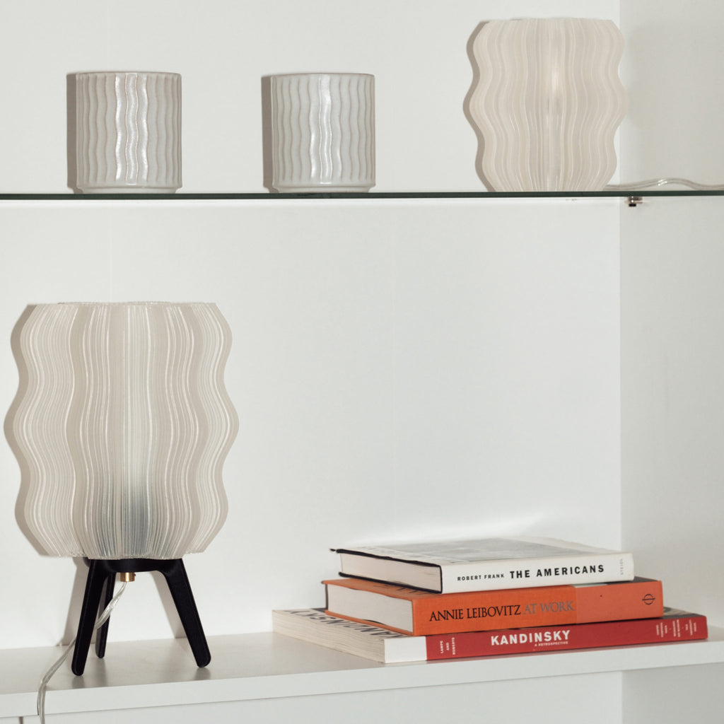 Wavy Lamp in matte black on bookshelf