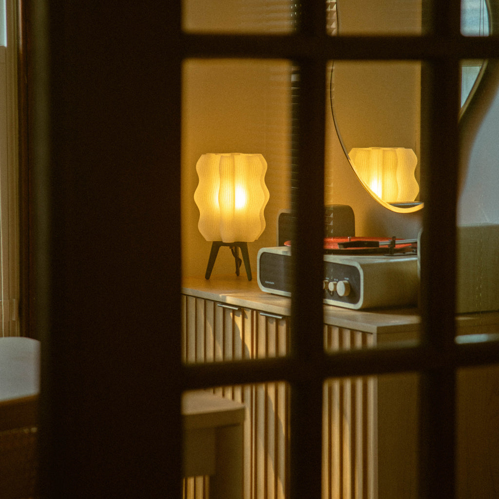Wavy Lamp in matte black on sideboard through door
