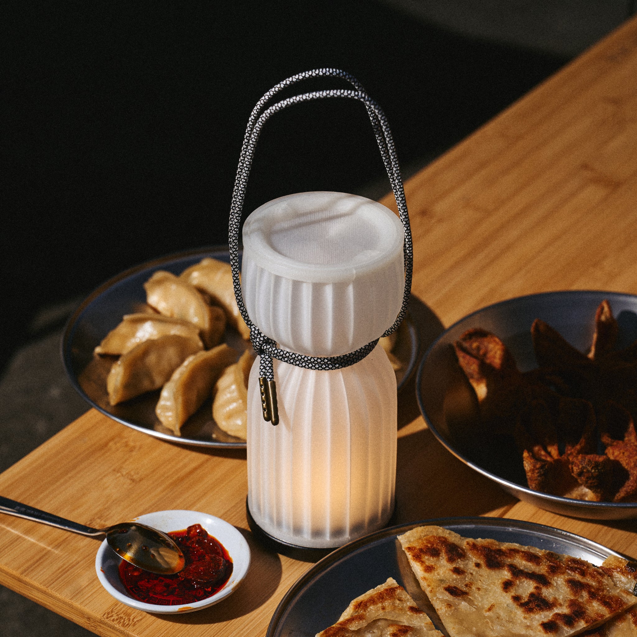 Cordless camp lantern surrounded by food on table