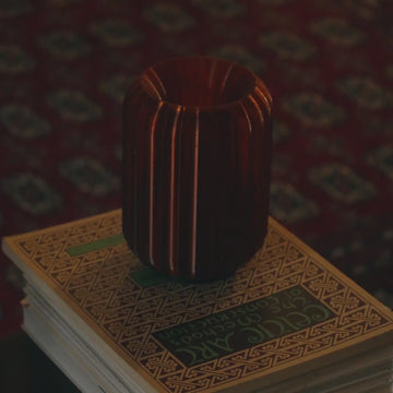 Cordless mini allium in amber on stack of books