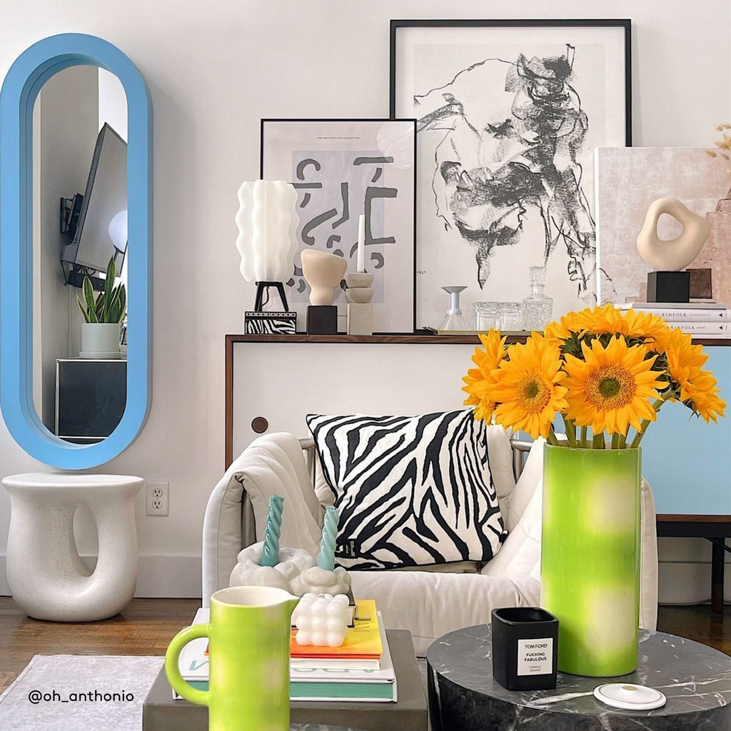 Tall Wavy Lamp in matte black on sideboard with sunflowers in foreground